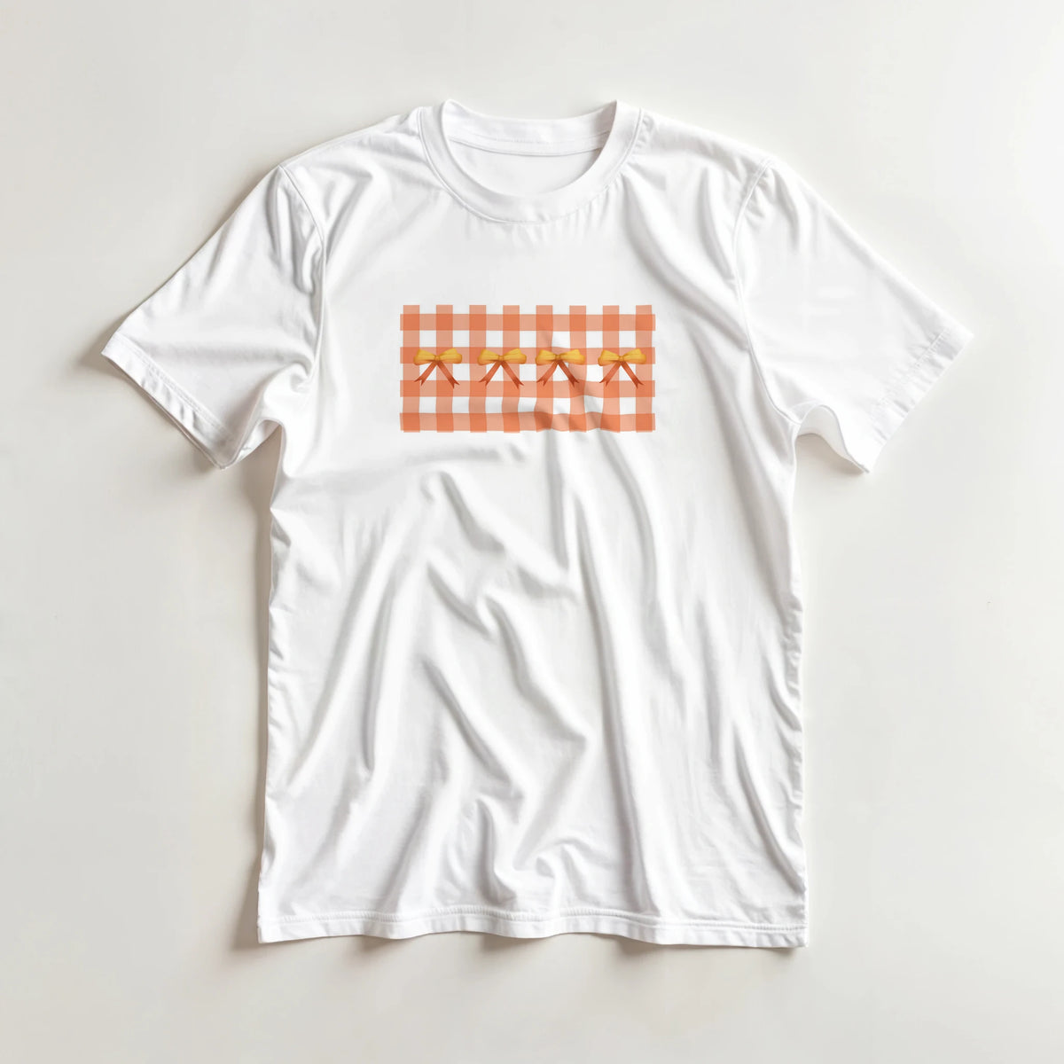 White women's T-shirt with orange gingham square pattern and bow accents for a Coquette aesthetic.