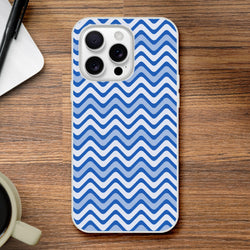 Blue wavy stripe iPhone case with retro geometric pattern on wooden desk. Matte TPU cover for iPhone 13-16 models.