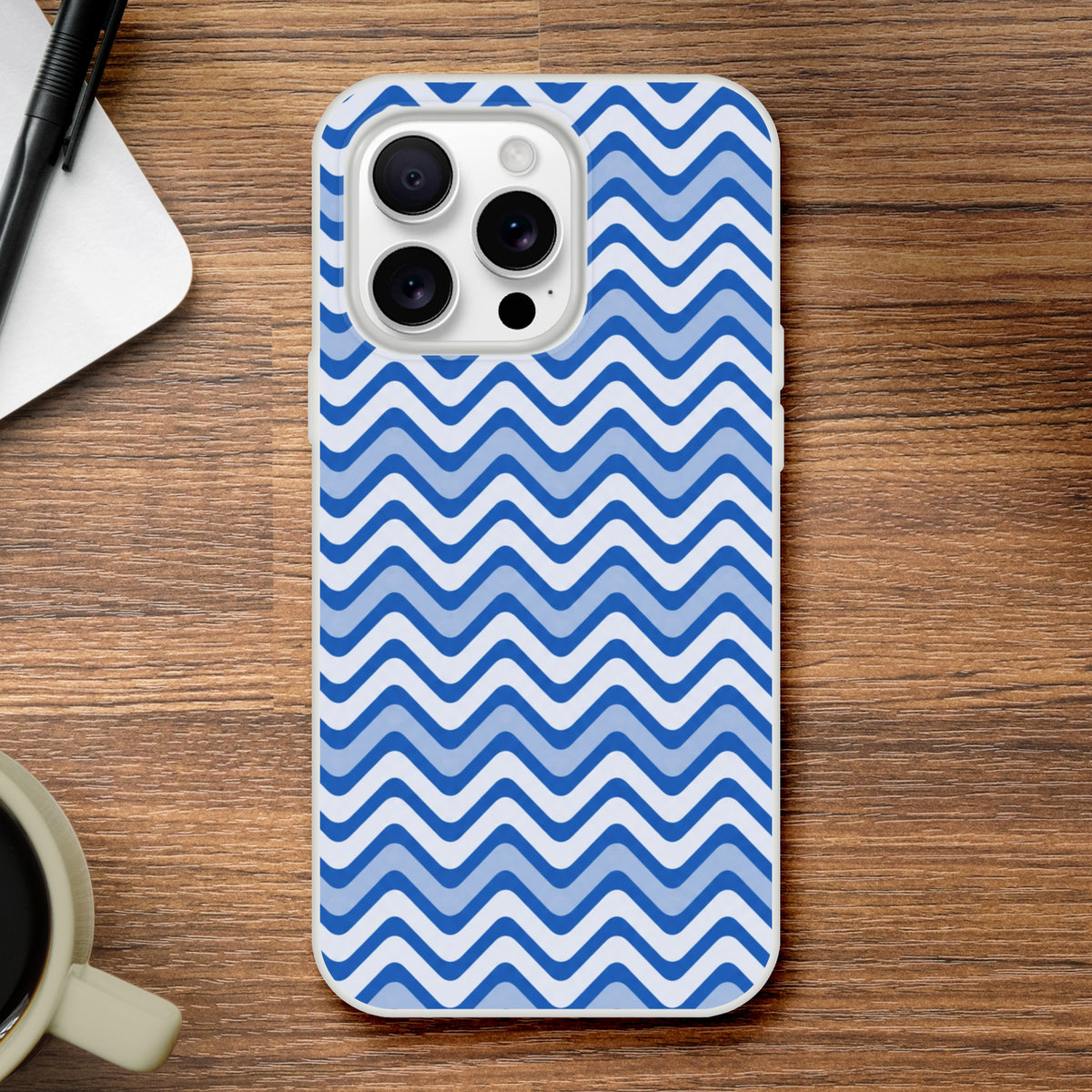 Blue wavy stripe iPhone case with retro geometric pattern on wooden desk. Matte TPU cover for iPhone 13-16 models.