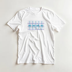 White women's T-shirt with a pastel blue gingham rectangle and blue bows on the front.