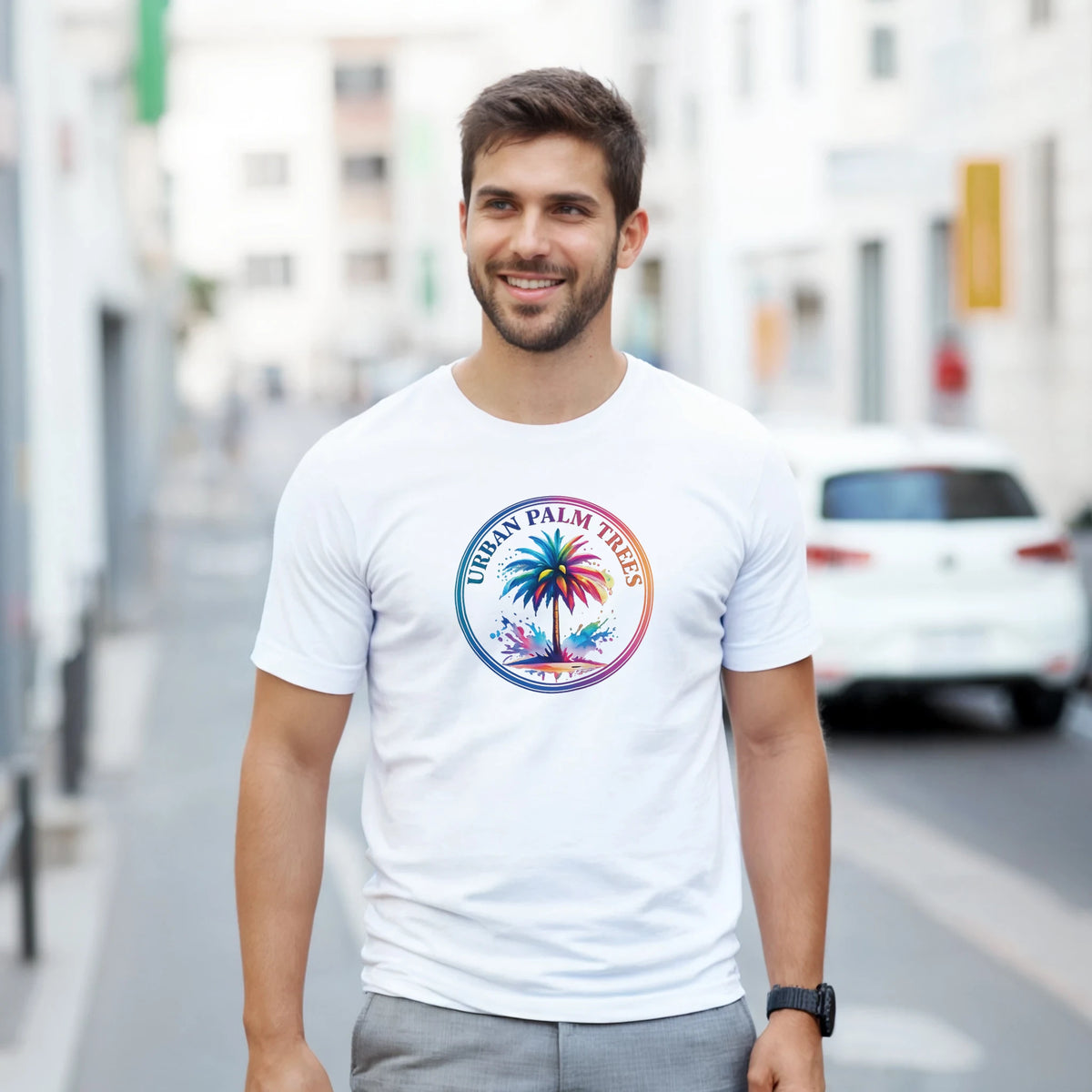 Smiling man wearing a white T-shirt with a colorful circular palm trees logo.