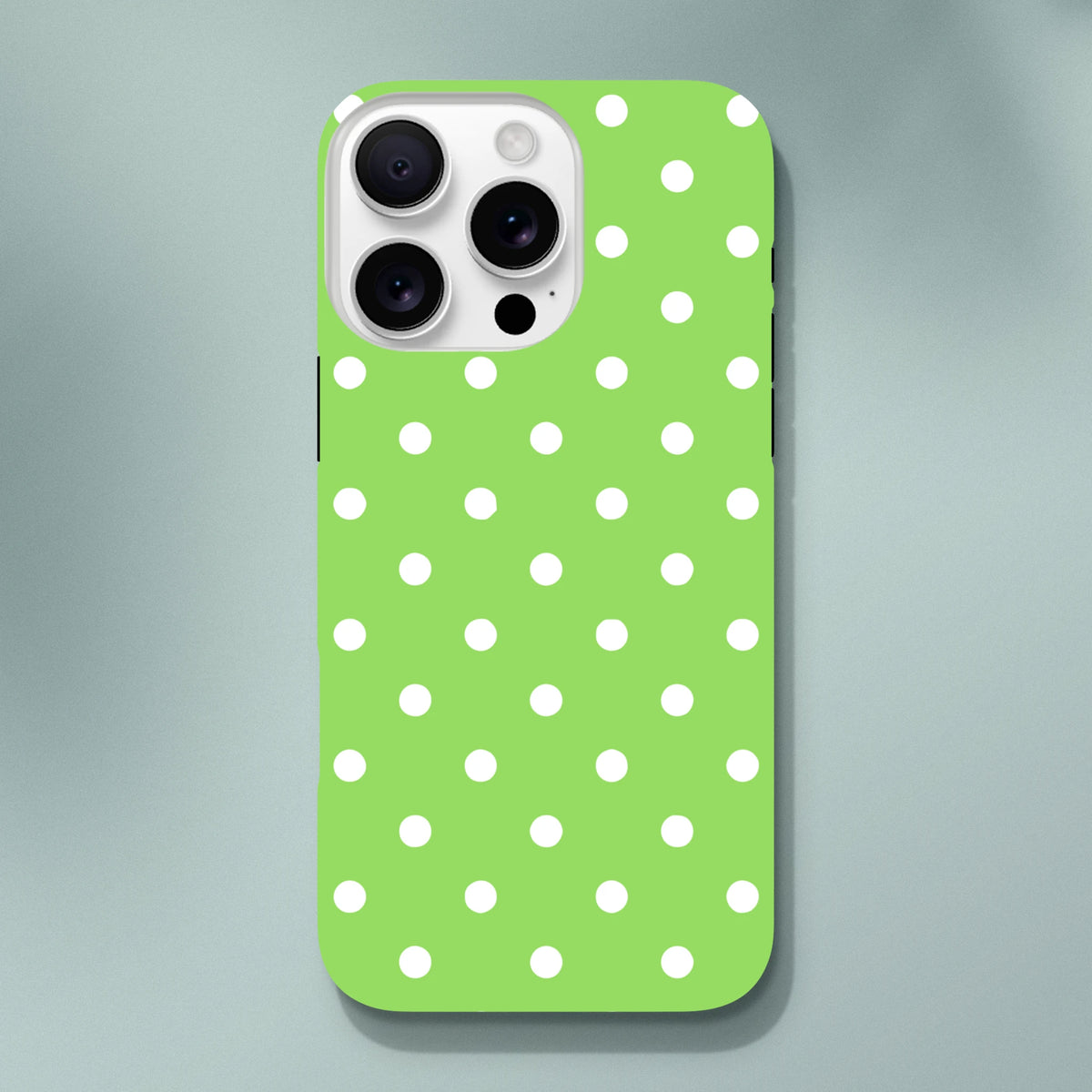 Green and white polka dot tough iPhone case featuring a cute design with shock-absorbing protection for models 13-16.