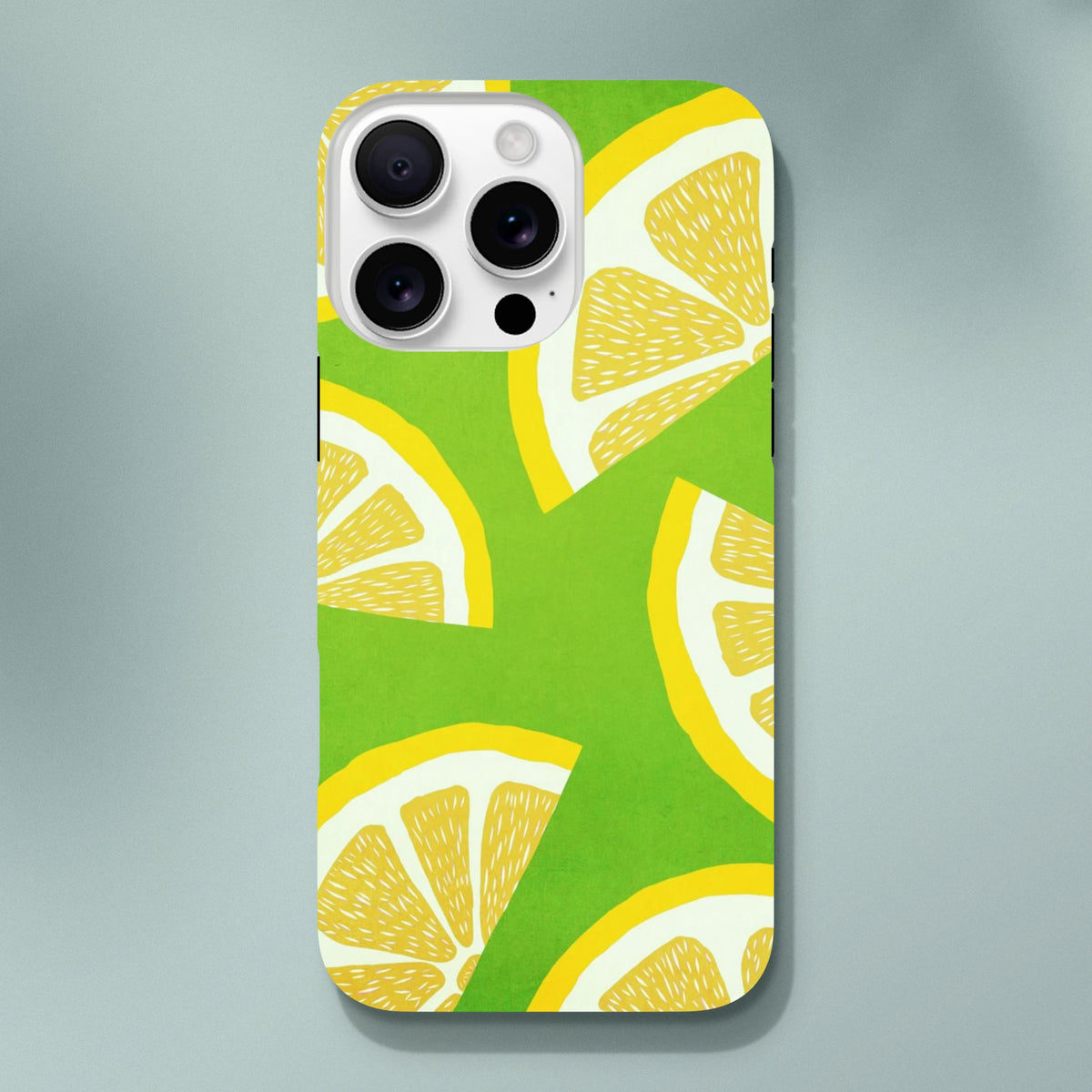 Green iPhone case featuring a bold yellow lemon slice pattern, designed as a shock-absorbing citrus fruit phone cover for urban commutes.