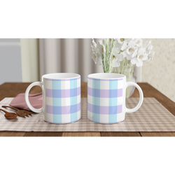 Three pastel blue gingham ceramic mugs on a checkered table with white flowers in the background.