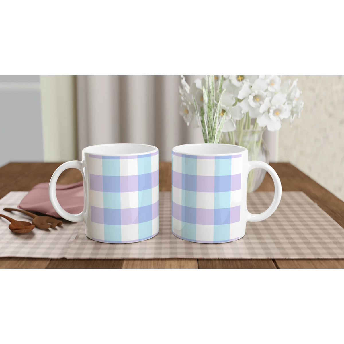 Three pastel blue gingham ceramic mugs on a checkered table with white flowers in the background.