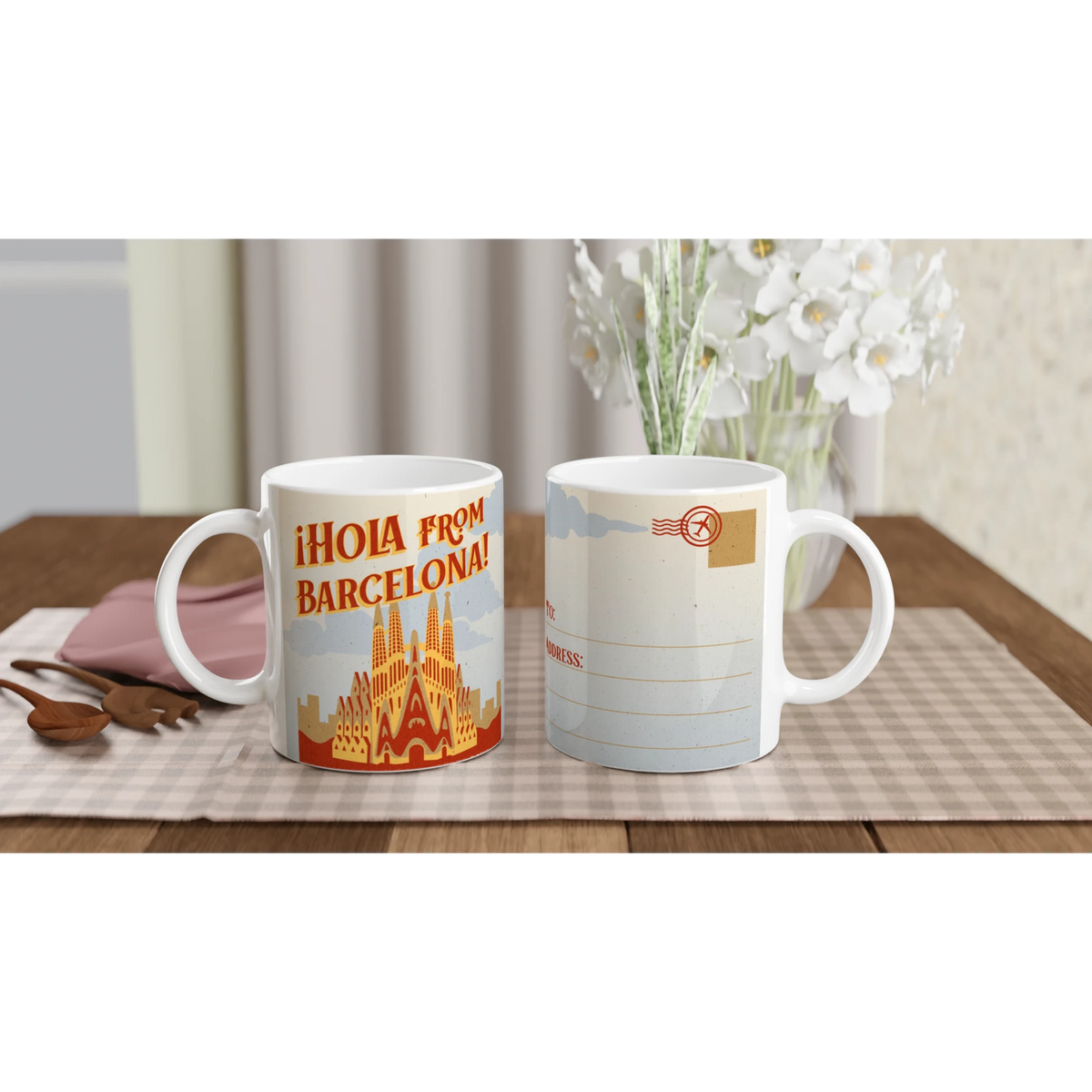 Two vintage Barcelona mugs with retro postcard artwork on a table beside white flowers.