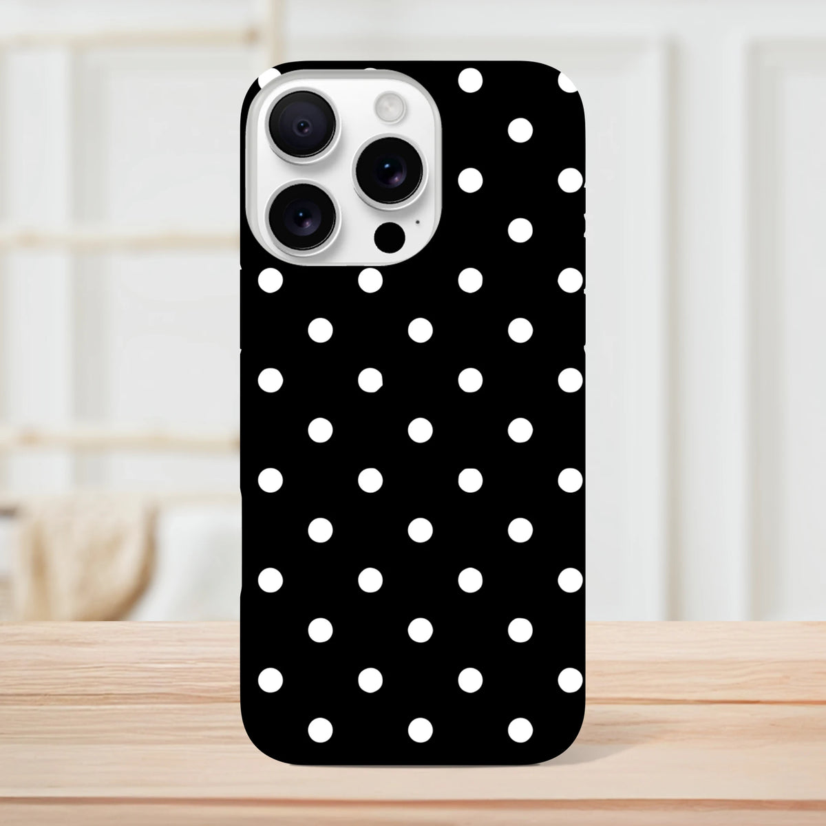 Black and white polka dot iPhone case with glossy finish, featuring a tough dual-layer design and shock-absorbing TPU core for impact protection.