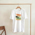 White women's short-sleeve crew-neck T-shirt with Tropical Dreamer palm-tree sunset graphic.