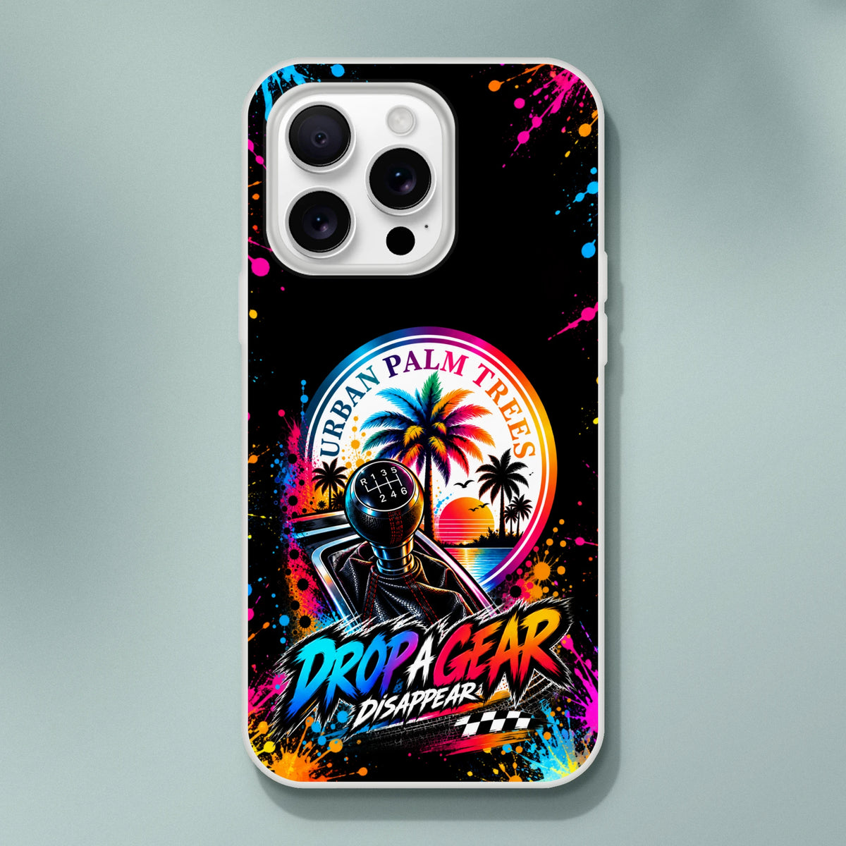 Vibrant iPhone case featuring a manual shifter, tropical sunset, and "Drop A Gear" text with colorful paint splatters.