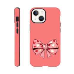 Pink iPhone case featuring a cute bow graphic patterned with small red and white hearts. Coquette style phone cover with protective bumpers.