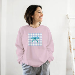 Pink pullover sweatshirt featuring a blue gingham square graphic with a cute blue bow for a coquette aesthetic look.
