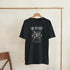 Outcast men's soft cotton blend graphic T-shirt in black with white gothic print on hanger