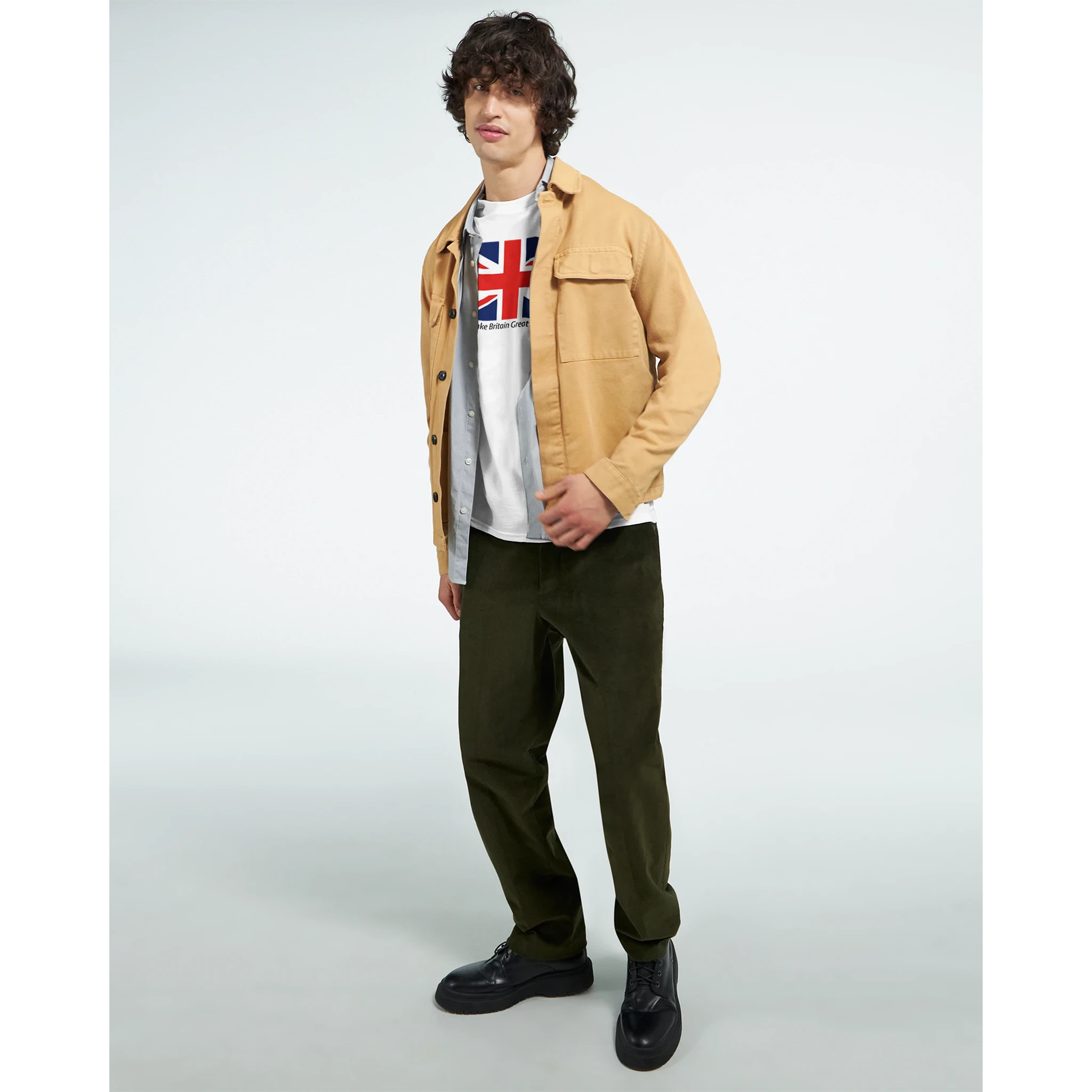Male model in Union Jack Make Britain Great Again slogan graphic T-shirt with tan jacket and dark pants.