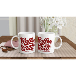 Pair of white ceramic mugs with red Coffee & Chill slogan on a checkered placemat.