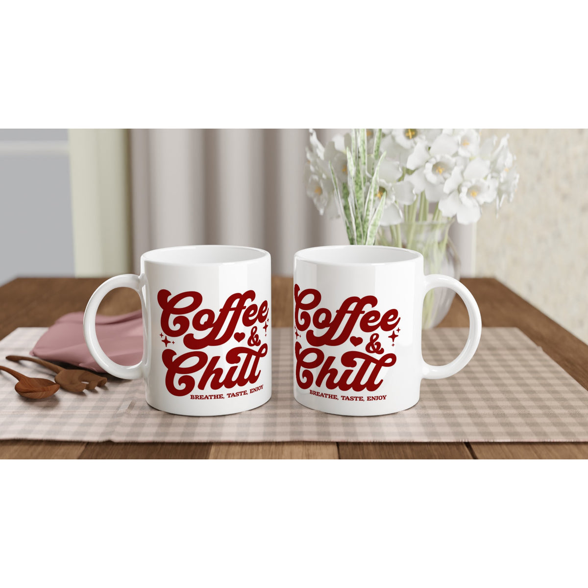 Pair of white ceramic mugs with red Coffee & Chill slogan on a checkered placemat.