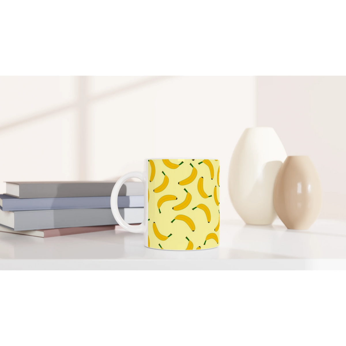 Yellow banana-pattern mug with banana print on a white desk.