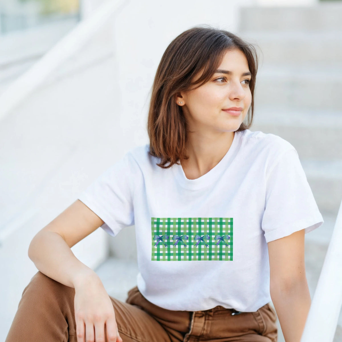Woman in white T-shirt with green bow gingham graphic, vintage Coquette aesthetic tee vibe.