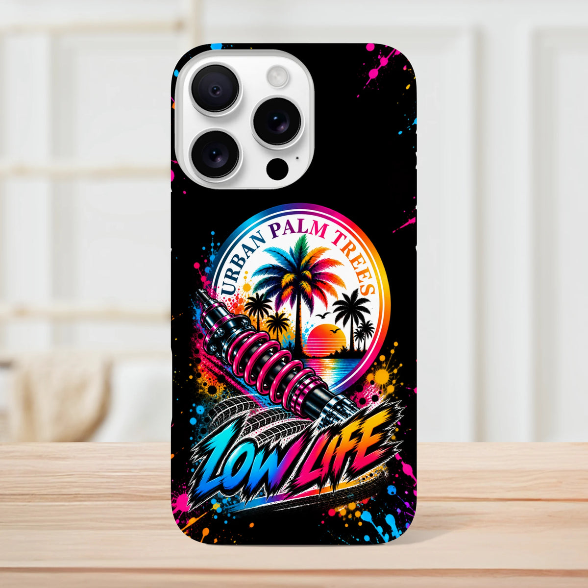 Low life petrolhead iPhone case featuring neon shock absorber, palm trees, and Urban Palm Trees sunset graphic on black background.