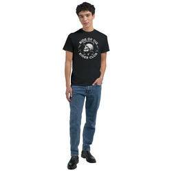 Model wearing black Motorcycle Club Graphic T-shirt with skull logo; cotton blend, crew neck, jeans and boots.