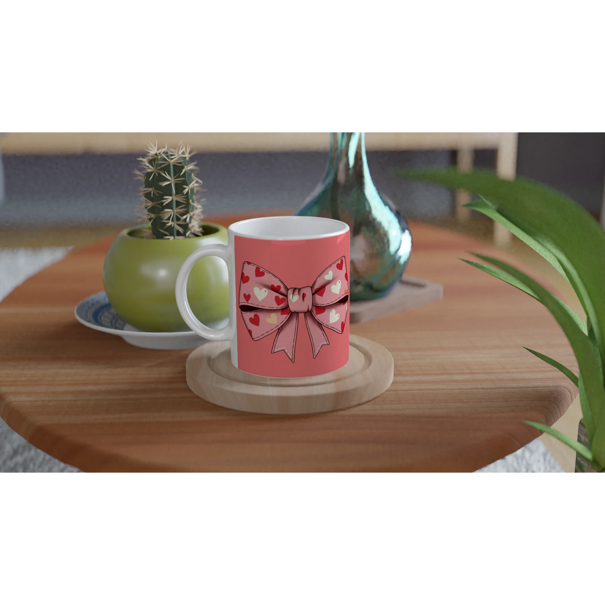 Pink coquette bow mug with hearts on a wooden table beside a cactus