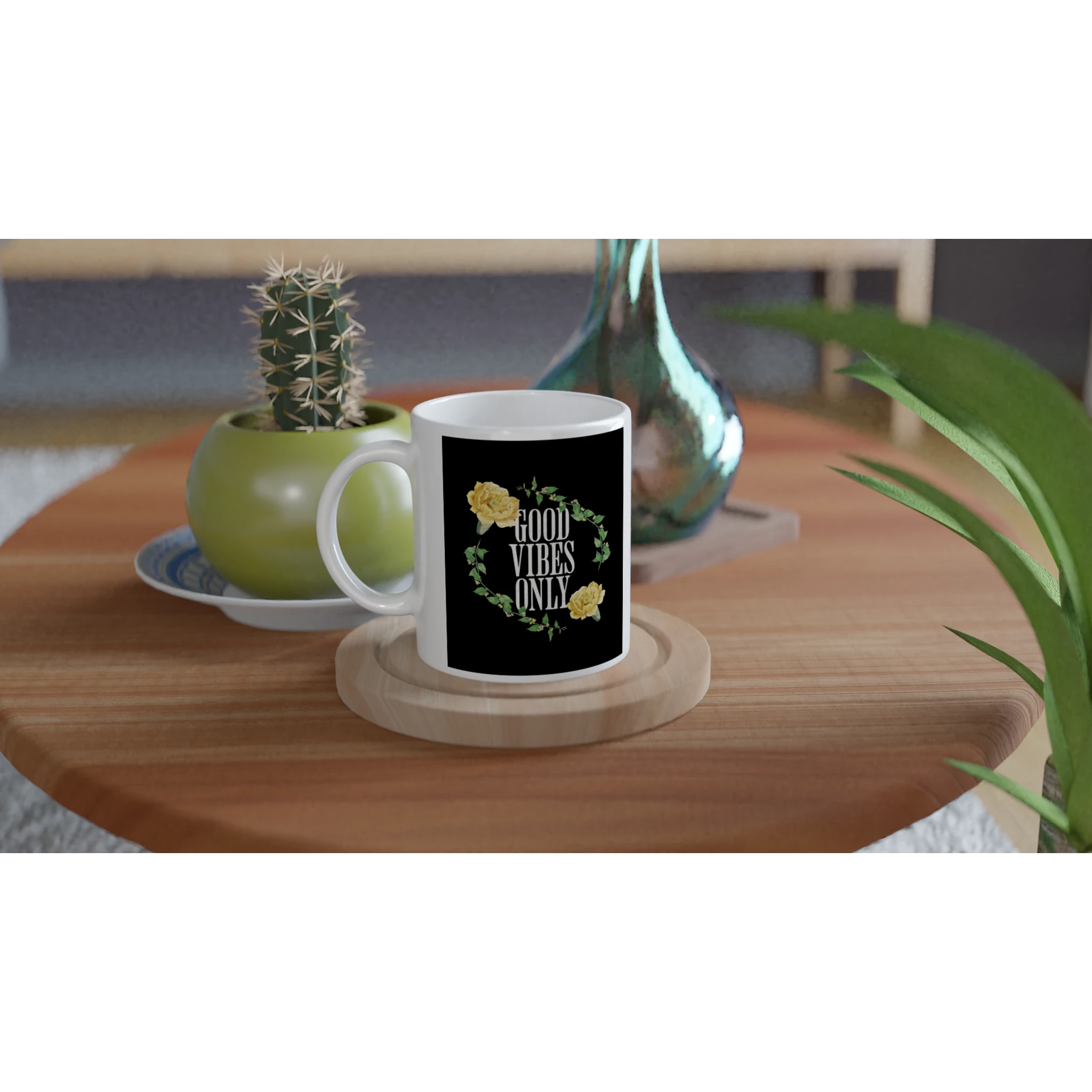 White ceramic mug with black label reading GOOD VIBES ONLY, surrounded by a green leafy wreath and yellow flowers.