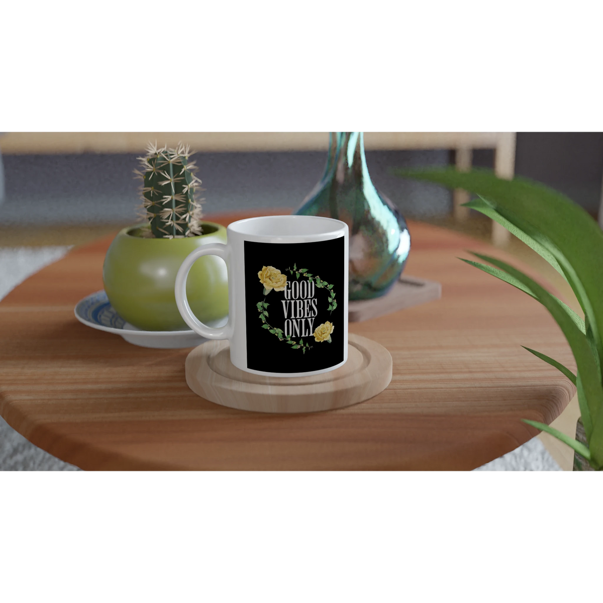 White ceramic mug with black label reading GOOD VIBES ONLY, surrounded by a green leafy wreath and yellow flowers.