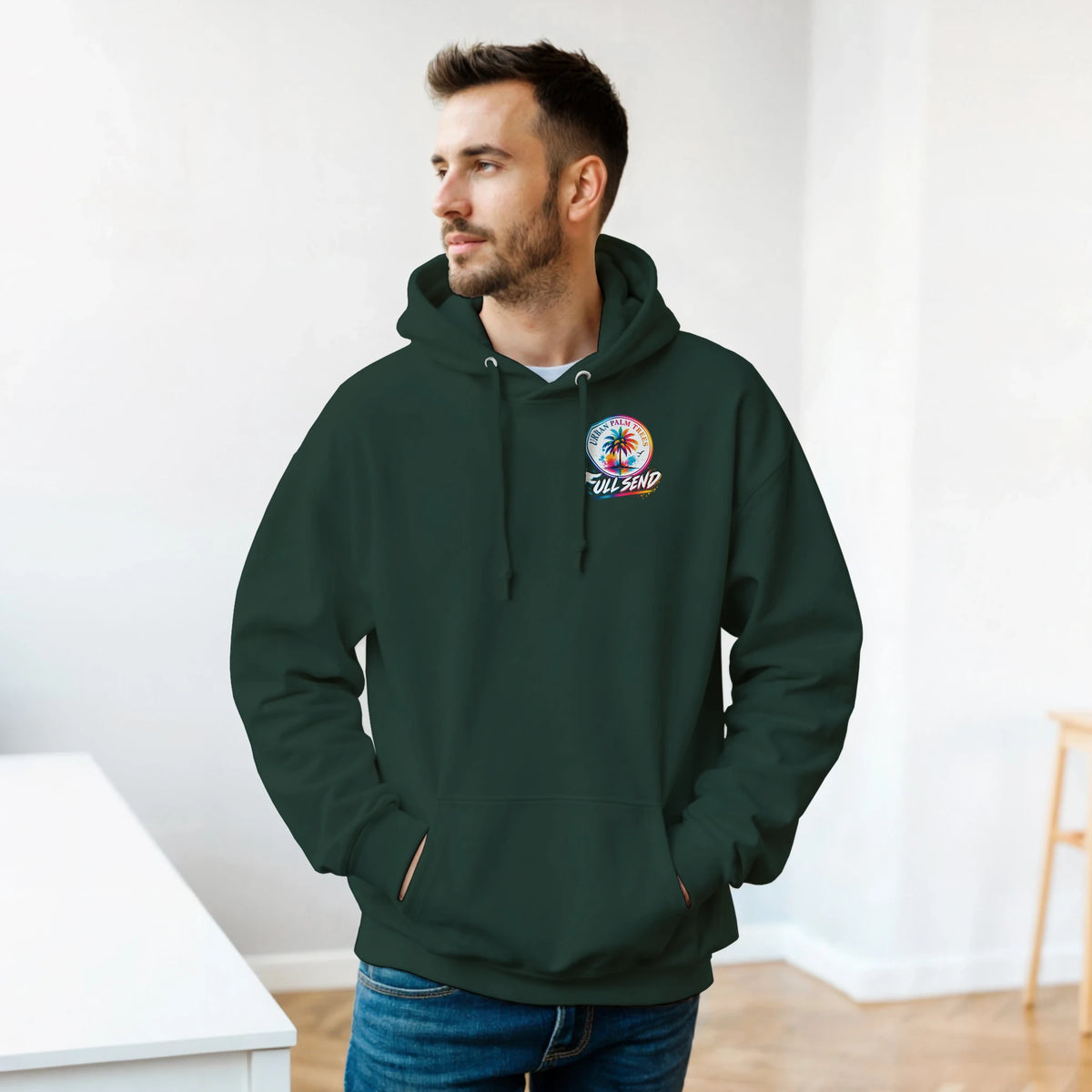 Man wearing dark green hoodie with colorful Urban Palm Trees Full Send graphic, front pouch pocket, and matching drawstrings.