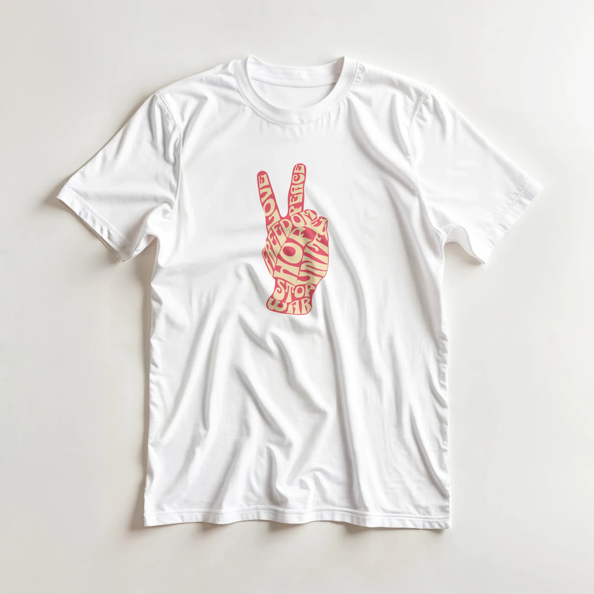 White tee featuring a pink retro peace sign hand graphic made of vintage typography with words like love, hope, and stop war.