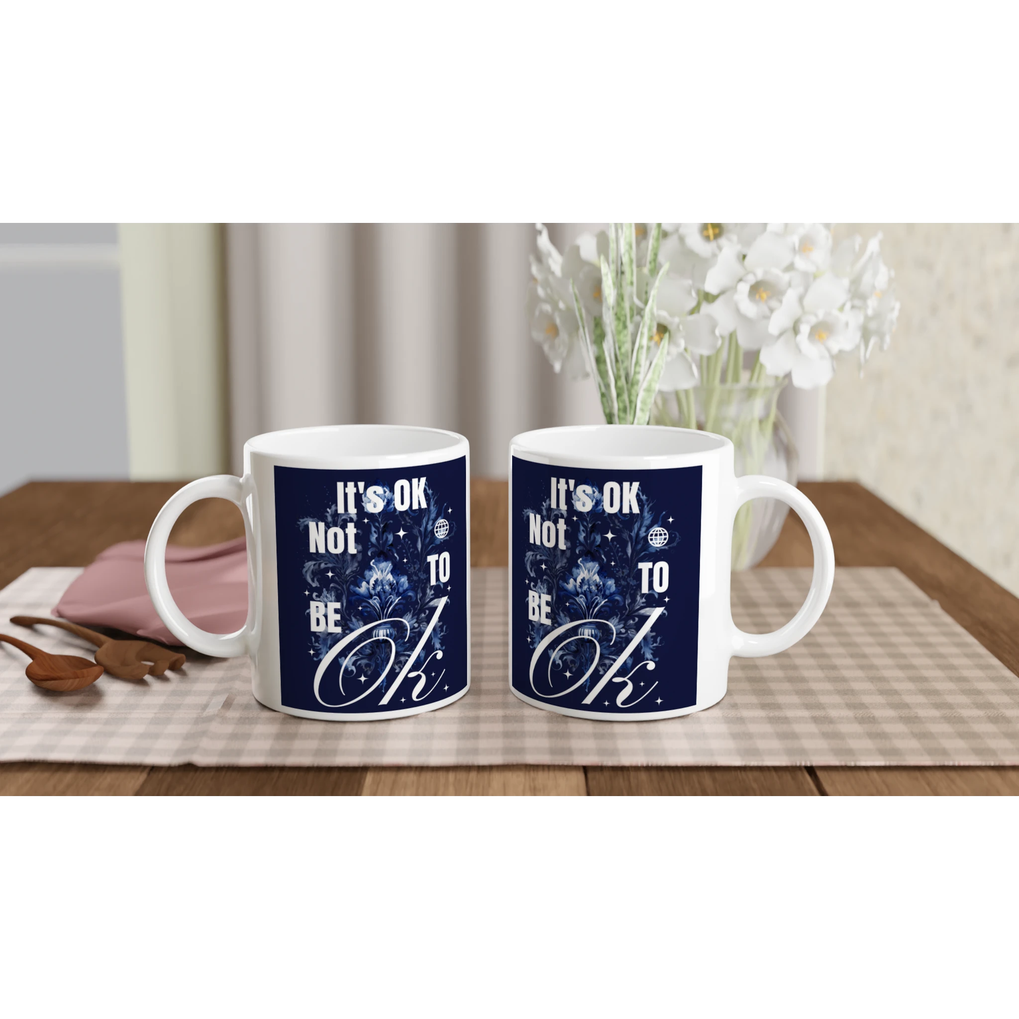 Pair of white ceramic mugs featuring navy It's OK Not To Be OK slogan, a thoughtful mental health gift.