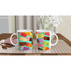 Two ceramic mugs featuring a retro colourful popsicle pattern on a turquoise background, set on a checkered placemat with wooden spoons.