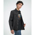 Male model wearing Cat DJ graphic tee with a colorful cat DJ print, layered under a black denim jacket.