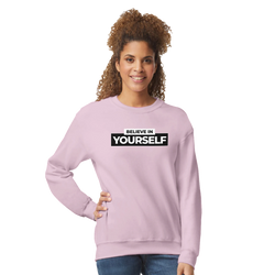 Woman in pastel pink Believe In Yourself sweatshirt with bold slogan for casual streetwear.
