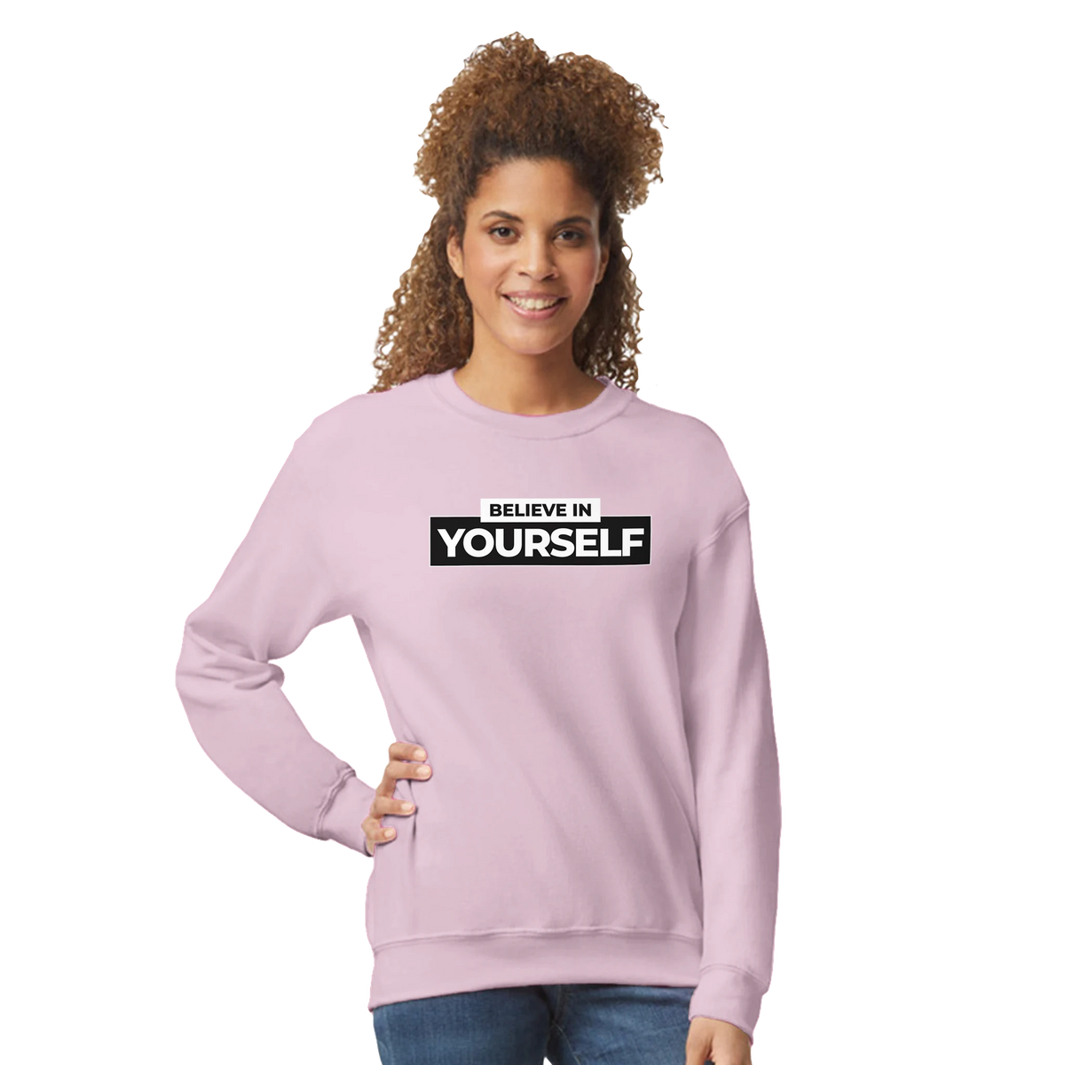 Woman in pastel pink Believe In Yourself sweatshirt with bold slogan for casual streetwear.