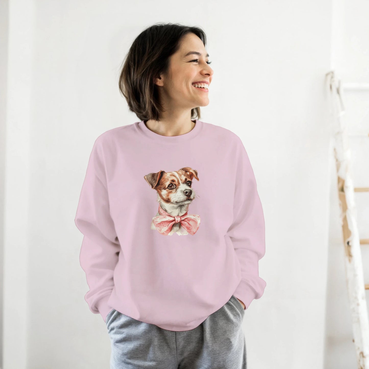 Woman in pastel pink Classic Unisex Crewneck Sweatshirt (Gildan 18000) with a dog graphic and pink bow.