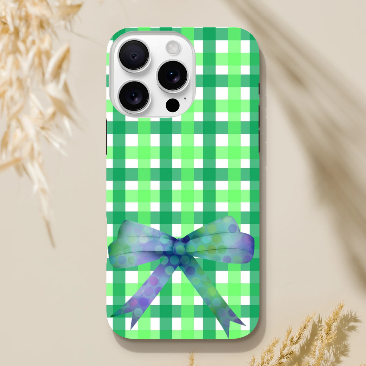 Green gingham iPhone case featuring a purple polka dot bow. Cute coquette tough phone cover for iPhone 13-16.