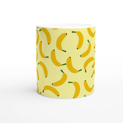 Cute banana-pattern mug on pale yellow with yellow bananas and green stems.