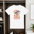 White t-shirt with a colorful graphic design hanging in a wardrobe.