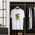 White t-shirt with a tropical sunset design hanging in a wardrobe.