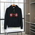 Black hoodie with cherry design on a hanger in a room with large windows.