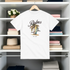 White t-shirt with 'Palms' design hanging on a rack with folded clothes in the background