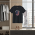 Black t-shirt with 'Made in USA' design hanging in a room with cityscape view
