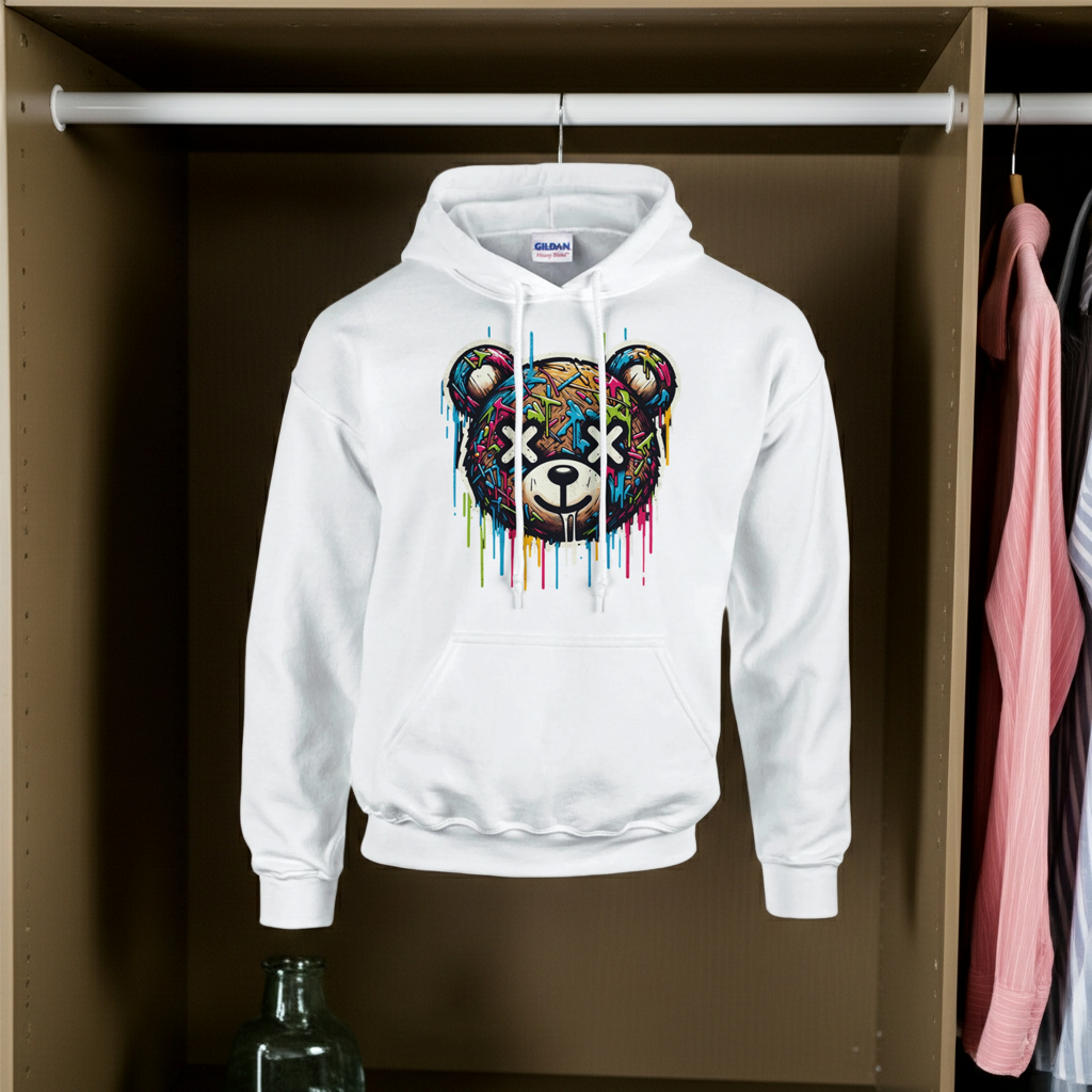 White hoodie with a colorful bear graphic hanging in a wardrobe.