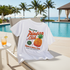 White t-shirt with Pineco Club graphic on a lounge chair by a poolside.