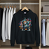 Black hoodie with colorful bear graphic on a hanger in a wardrobe.