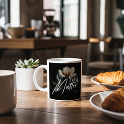 Mug with 'You Matter' design on a table with pastries and plants