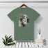 Green t-shirt with classical statue graphic on a hanger against a white wall.