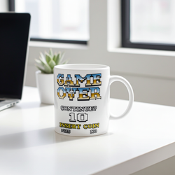 90's arcade mug: white ceramic with retro pixel-art GAME OVER and Insert Coin on a desk.