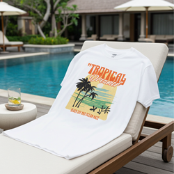 White t-shirt with tropical design on a lounge chair by a poolside.