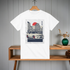 White t-shirt with car graphic on a wooden shelf against a gray wall.