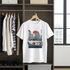 White t-shirt with car graphic on a hanger in a wardrobe.